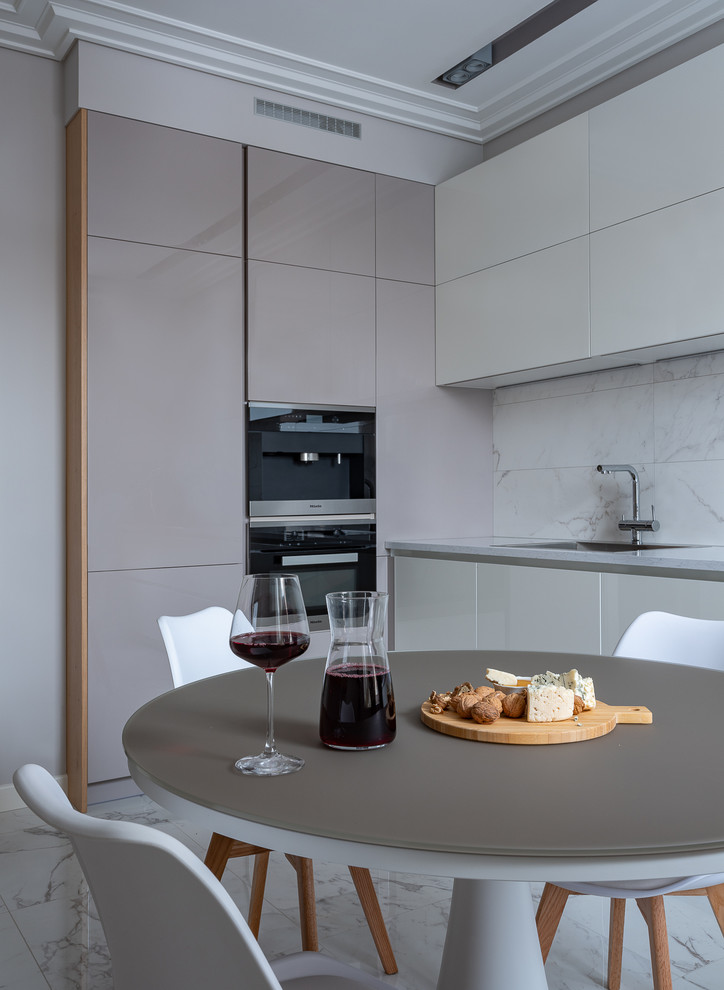 Mid-sized contemporary single-wall separate kitchen in Moscow with flat-panel cabinets, white cabinets, quartz benchtops, white splashback, ceramic splashback, stainless steel appliances, porcelain floors, no island, white floor, white benchtop and an undermount sink.