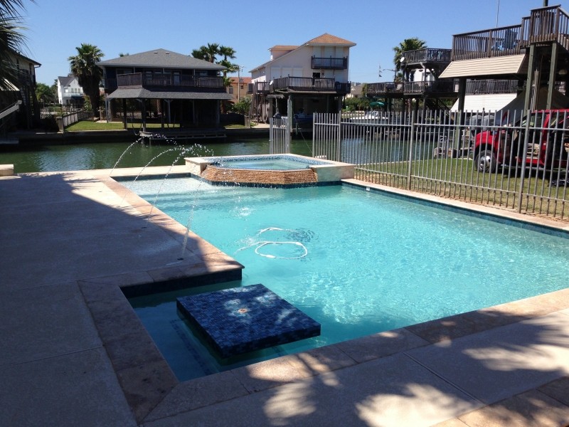Mid-sized transitional backyard stamped concrete and custom-shaped pool fountain photo in Houston