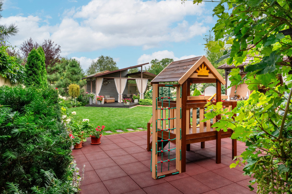 Источник вдохновения для домашнего уюта: большая солнечная, летняя спортивная площадка на внутреннем дворе в современном стиле с детским городком, хорошей освещенностью, настилом и с деревянным забором