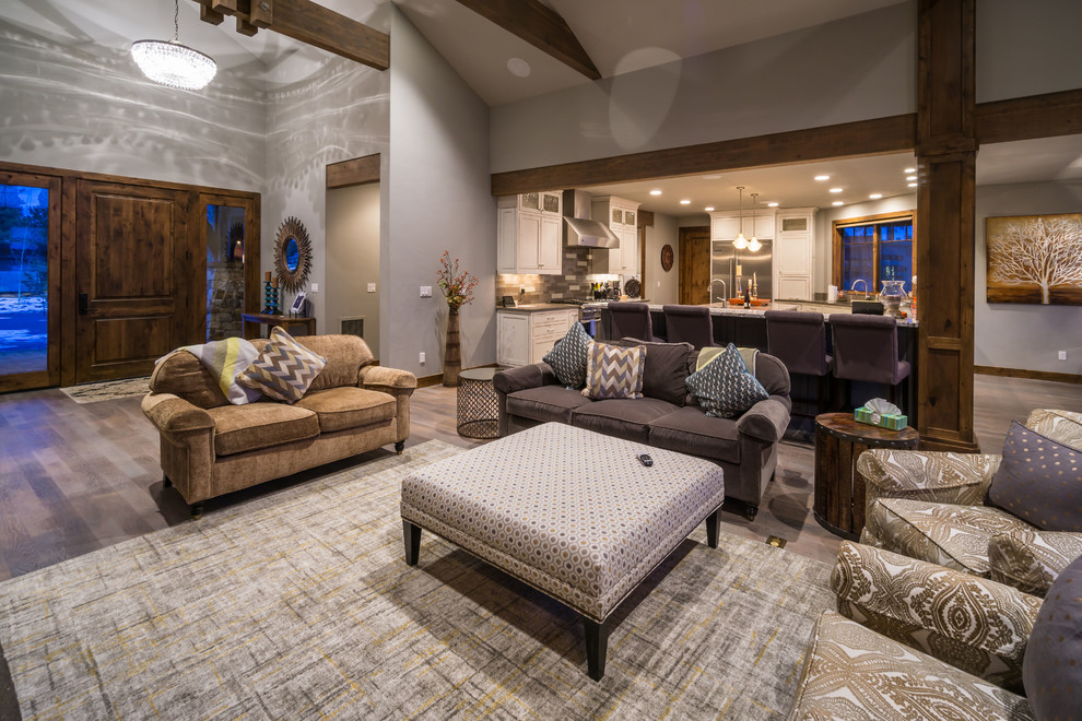 This is an example of a large country open concept living room in Other with grey walls, medium hardwood floors, a standard fireplace and a stone fireplace surround.