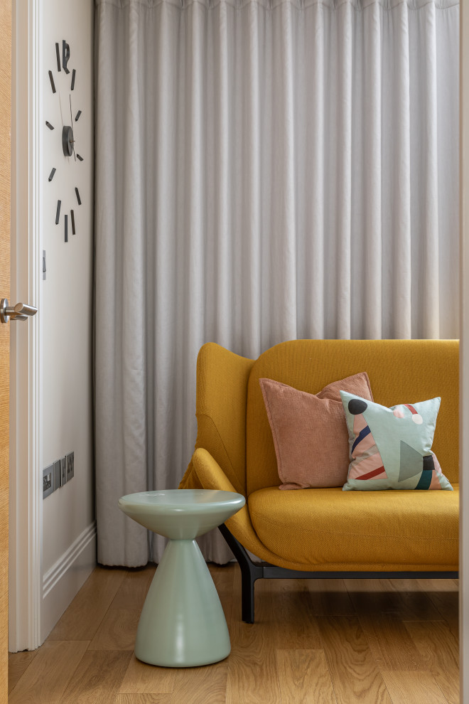 Immagine di una camera degli ospiti minimal con pareti beige e pavimento in legno massello medio