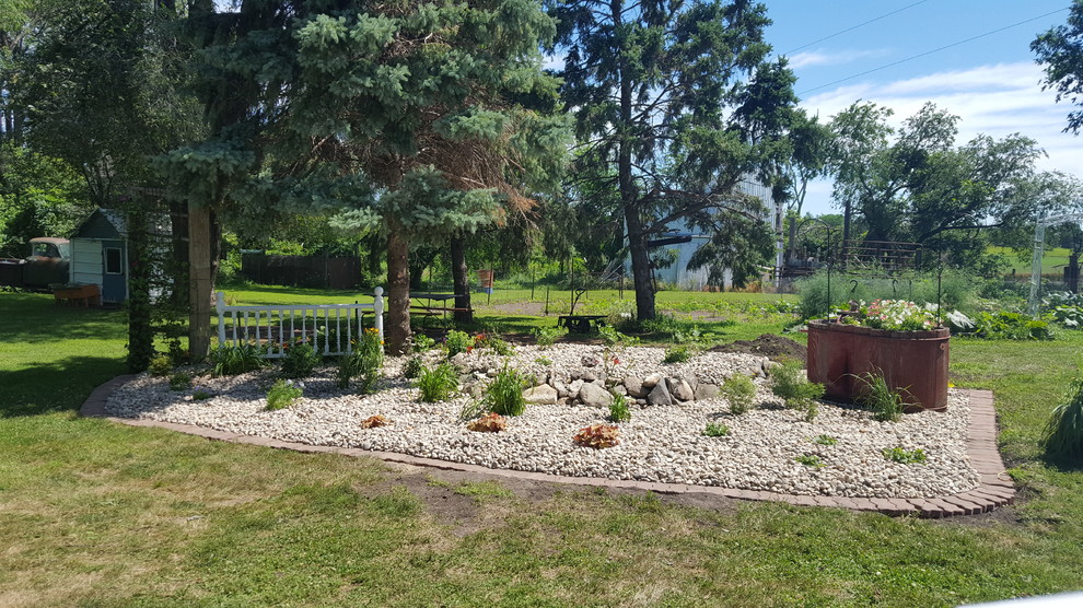 This is an example of a rustic full sun backyard brick landscaping for summer.
