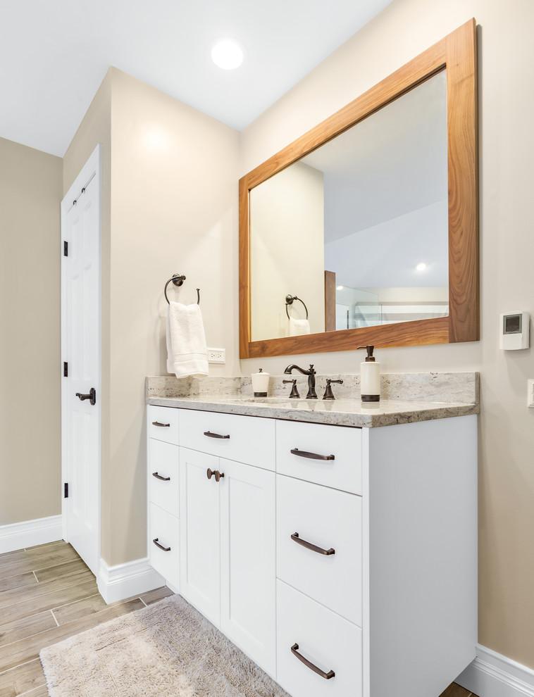 Photo of a large contemporary master bathroom in Chicago with flat-panel cabinets, white cabinets, a freestanding tub, an open shower, a one-piece toilet, beige walls, ceramic floors, an undermount sink, granite benchtops, grey floor, an open shower and multi-coloured benchtops.