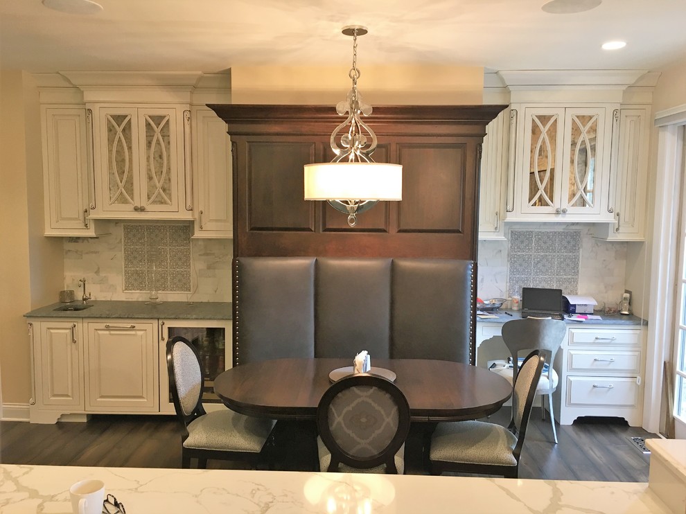 Kitchen pantry - large transitional dark wood floor kitchen pantry idea in Chicago with a farmhouse sink, beaded inset cabinets, white cabinets, marble countertops, white backsplash, stone tile backsplash, stainless steel appliances and an island