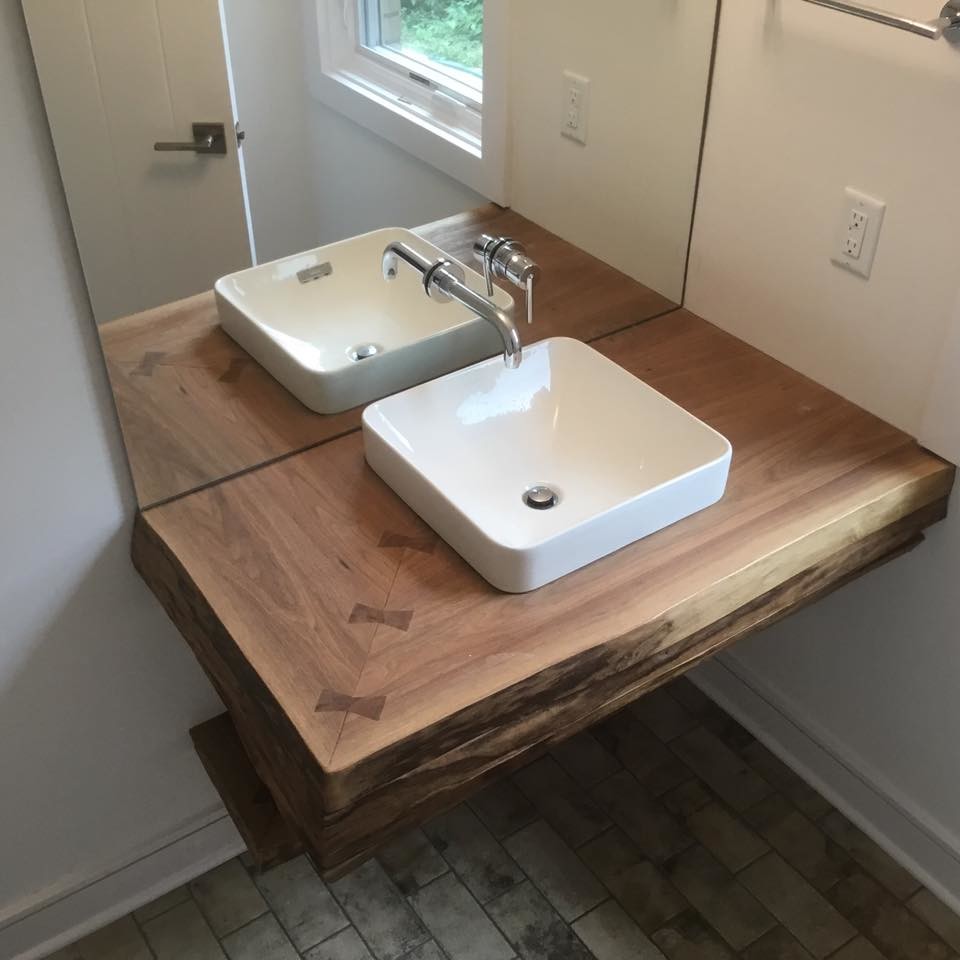 Design ideas for a small country 3/4 bathroom in Indianapolis with white walls, a vessel sink, wood benchtops and black floor.