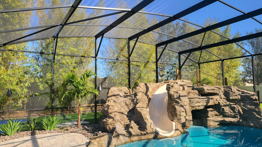 Mittelgroßer Schwimmteich hinter dem Haus in individueller Form mit Wasserrutsche und Pflastersteinen in Orlando