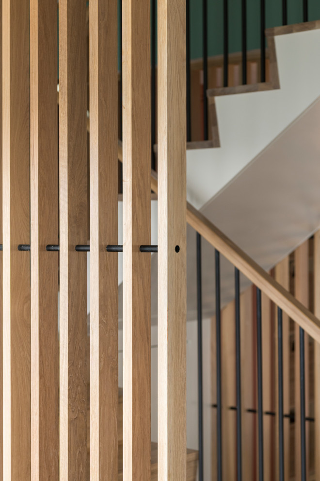 Foto de escalera en U nórdica de tamaño medio con escalones de madera, contrahuellas de madera y barandilla de madera
