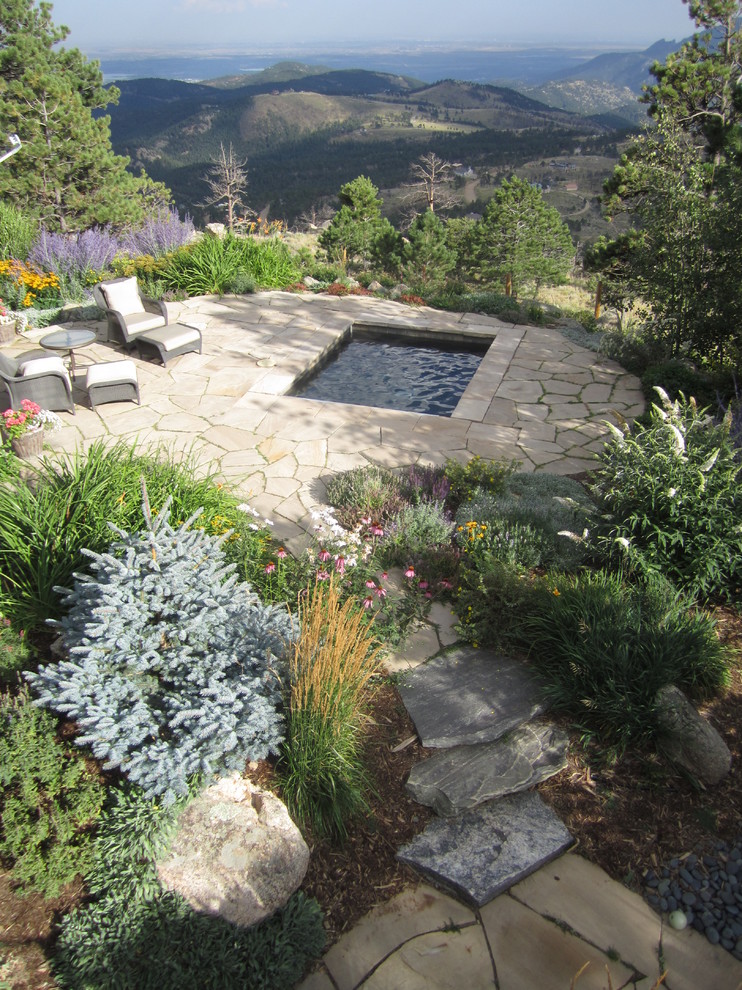 Design ideas for a large eclectic backyard patio in Denver with natural stone pavers.