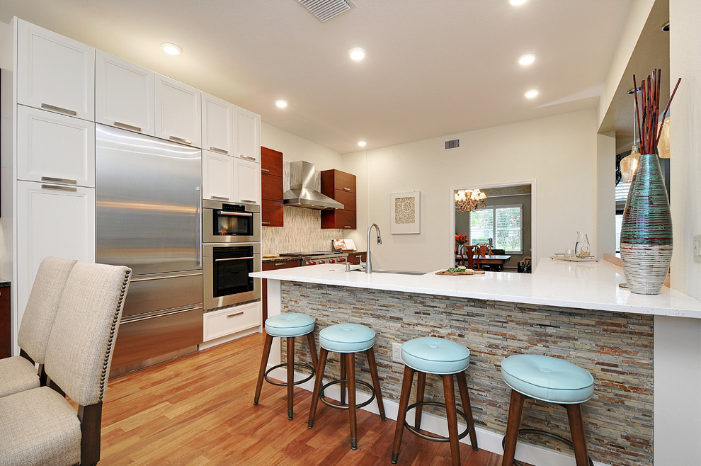Example of a large transitional l-shaped dark wood floor open concept kitchen design in Tampa with a farmhouse sink, gray backsplash, matchstick tile backsplash, stainless steel appliances and an island