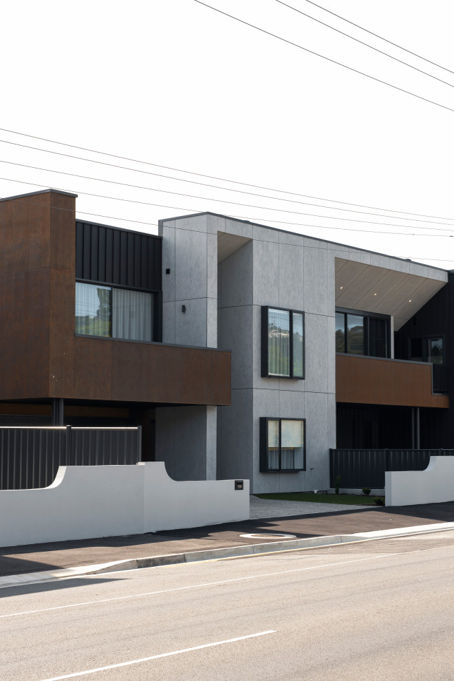 Стильный дизайн: трехэтажный, черный таунхаус среднего размера в стиле лофт с облицовкой из бетона, плоской крышей, металлической крышей, черной крышей и отделкой доской с нащельником - последний тренд