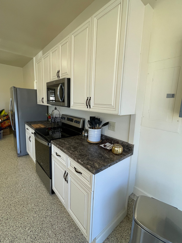 Photo of a galley separate kitchen in St Louis with raised-panel cabinets, white cabinets and laminate benchtops.