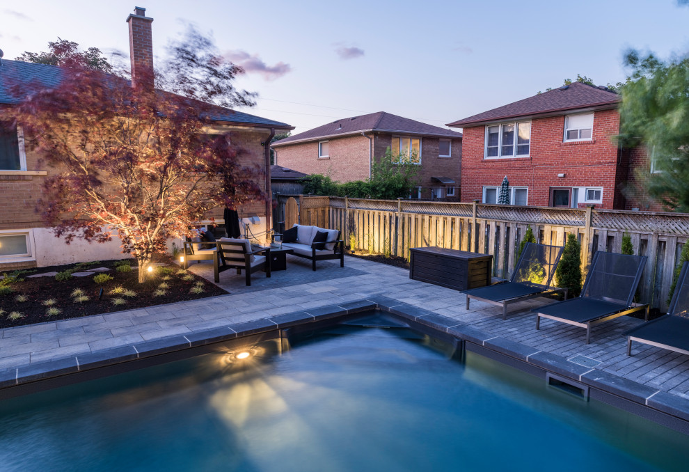 Inspiration for a mid-sized transitional backyard concrete paver and l-shaped lap pool fountain remodel in Toronto
