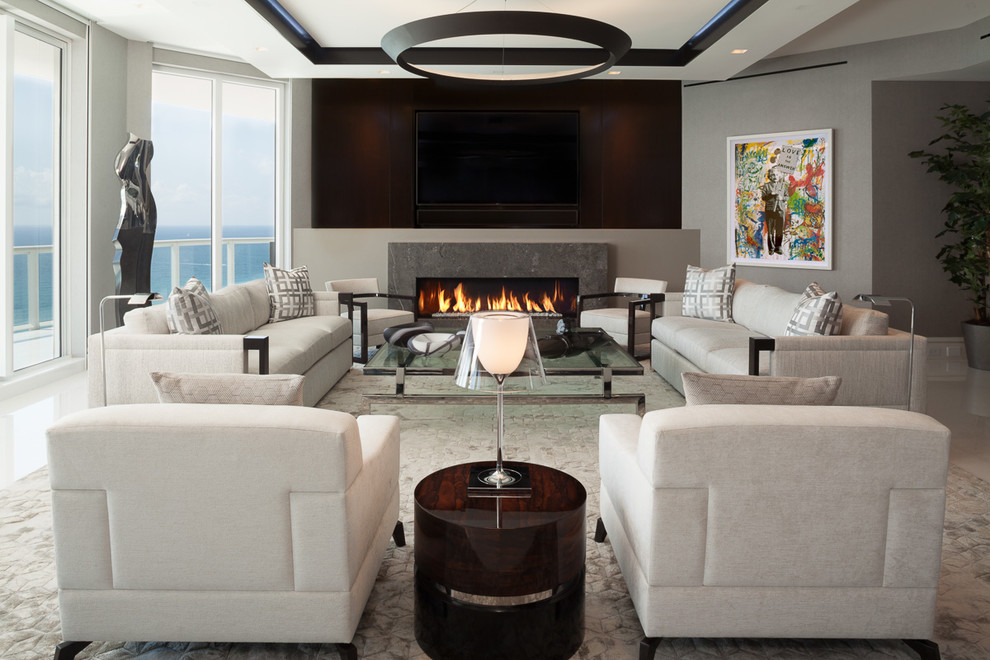 Photo of a large contemporary family room in Miami with grey walls, marble floors, a stone fireplace surround, a ribbon fireplace and a wall-mounted tv.