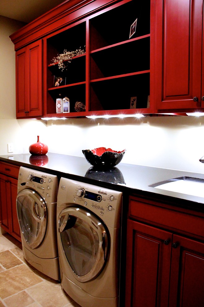 Inspiration for a mid-sized eclectic single-wall dedicated laundry room in Grand Rapids with an undermount sink, recessed-panel cabinets, red cabinets, quartz benchtops, beige walls, ceramic floors and a side-by-side washer and dryer.