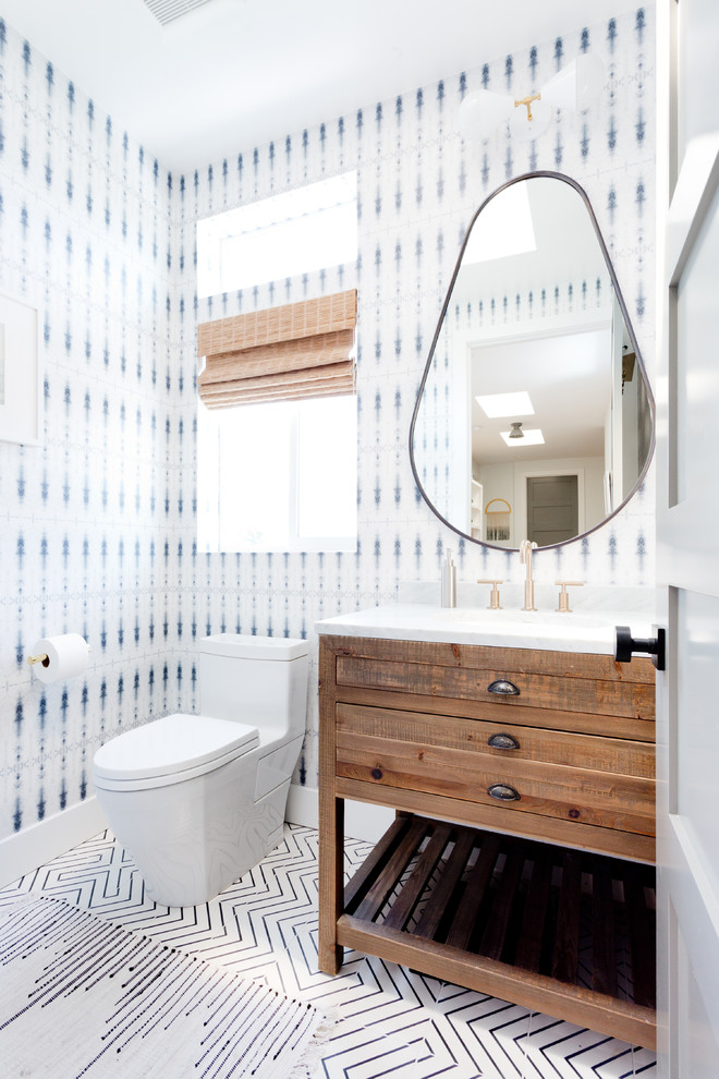 This is an example of a beach style powder room in Los Angeles with furniture-like cabinets, medium wood cabinets, multi-coloured walls and multi-coloured floor.