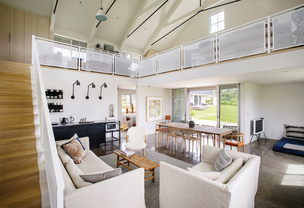 This is an example of a country open concept living room in Portland with white walls, concrete floors and grey floor.