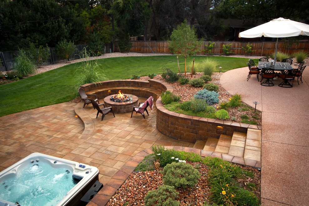 Design ideas for a mid-sized transitional backyard patio in Denver with a fire feature, natural stone pavers and no cover.