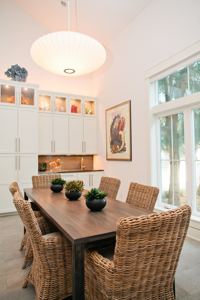 Photo of a beach style dining room in Austin with white walls.