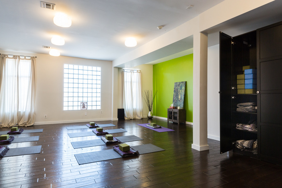 Large contemporary home yoga studio in New York with white walls and dark hardwood floors.