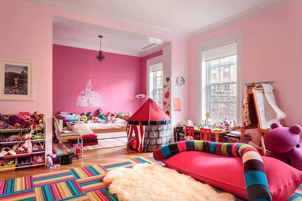 Inspiration for an expansive traditional kids' bedroom for kids 4-10 years old and girls in New York with pink walls and light hardwood floors.
