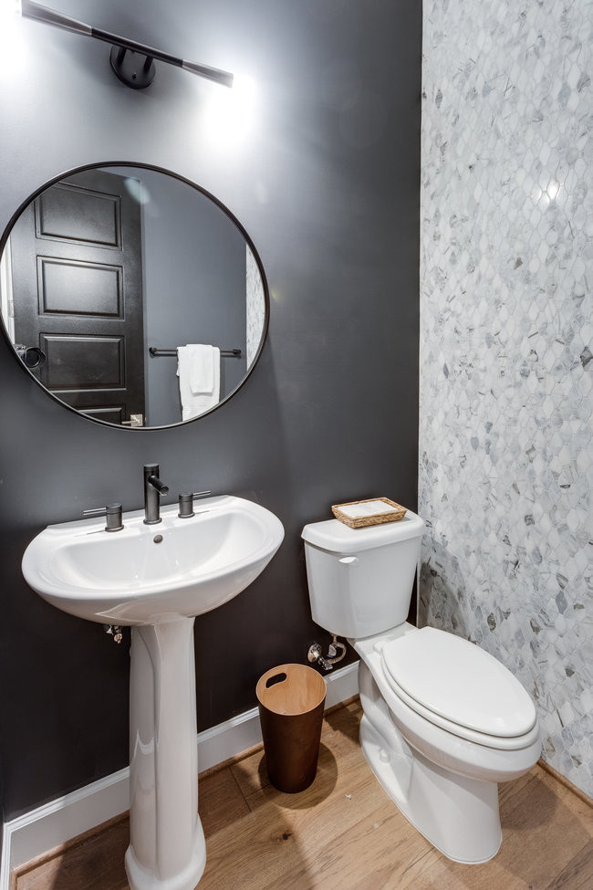 ワシントンD.C.にあるラグジュアリーな中くらいなトランジショナルスタイルのおしゃれなトイレ・洗面所 (グレーの壁、無垢フローリング、ペデスタルシンク、茶色い床) の写真
