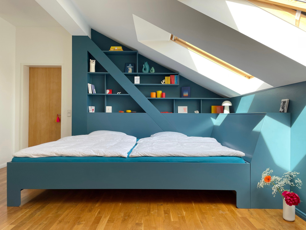 ベルリンにある中くらいなコンテンポラリースタイルのおしゃれな主寝室 (青い壁、淡色無垢フローリング、茶色い床、表し梁)