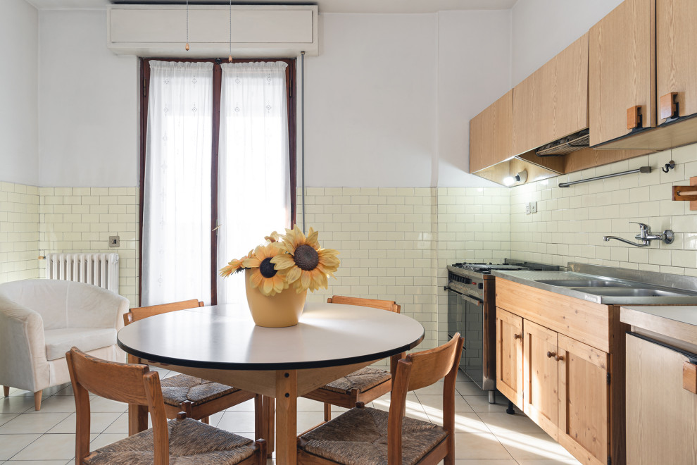 Свежая идея для дизайна: прямая кухня среднего размера в стиле модернизм с обеденным столом, полом из керамической плитки, белым полом, двойной мойкой, плоскими фасадами, бежевыми фасадами, столешницей из ламината, желтым фартуком, фартуком из керамогранитной плитки, техникой из нержавеющей стали и бежевой столешницей - отличное фото интерьера