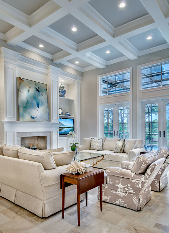 This is an example of an expansive transitional open concept family room in Miami with a library, grey walls, travertine floors, a standard fireplace, a tile fireplace surround and a built-in media wall.