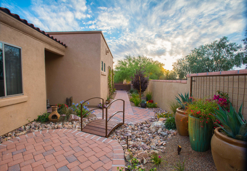 Inspiration for a mid-sized and desert look side yard partial sun xeriscape in Phoenix with brick pavers.