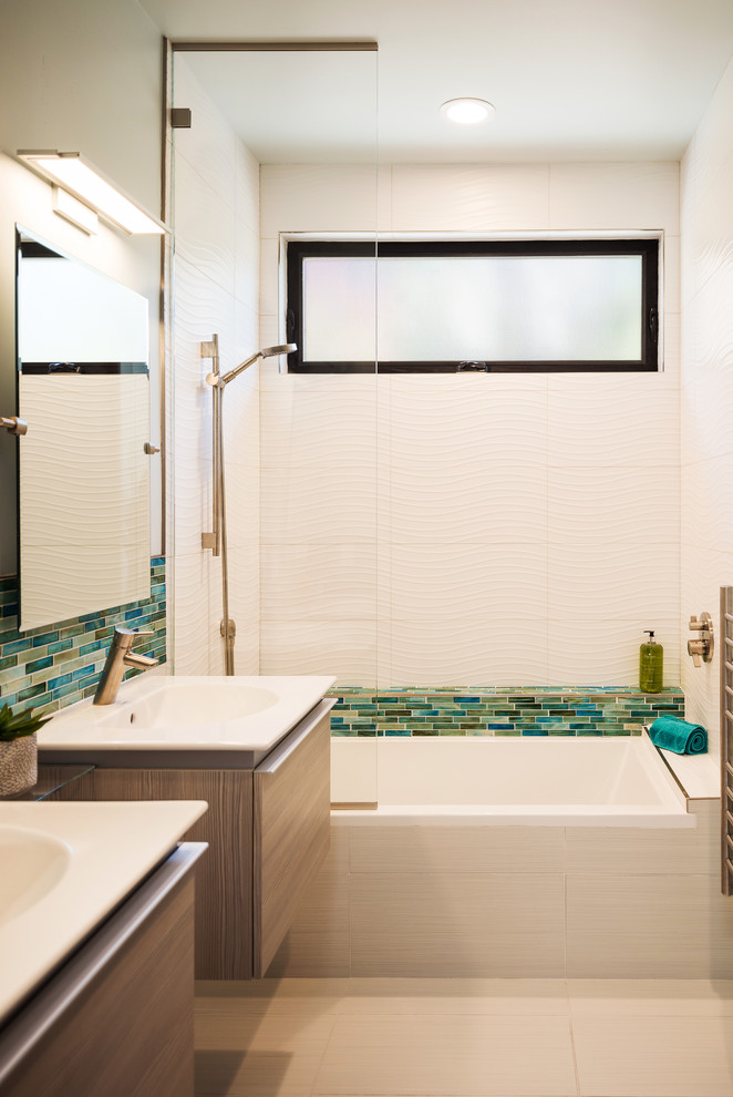 Photo of a mid-sized contemporary kids bathroom in San Diego with flat-panel cabinets, medium wood cabinets, a shower/bathtub combo, white tile, porcelain tile, porcelain floors, solid surface benchtops, beige floor, an open shower, an alcove tub and a console sink.