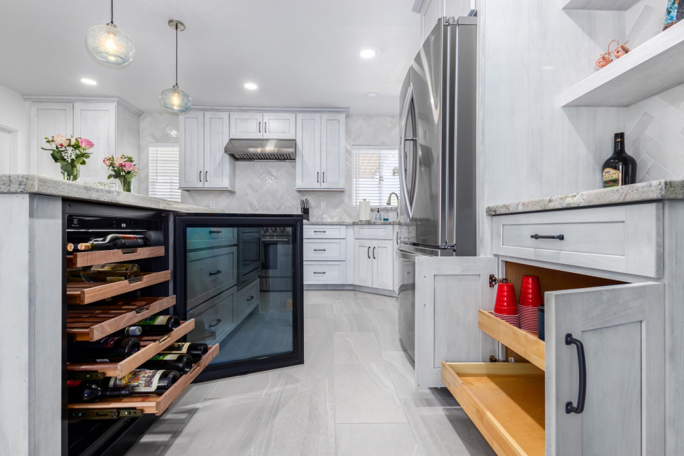 Transitional l-shaped kitchen photo in Phoenix with a single-bowl sink, shaker cabinets, white cabinets, granite countertops, white backsplash and stainless steel appliances