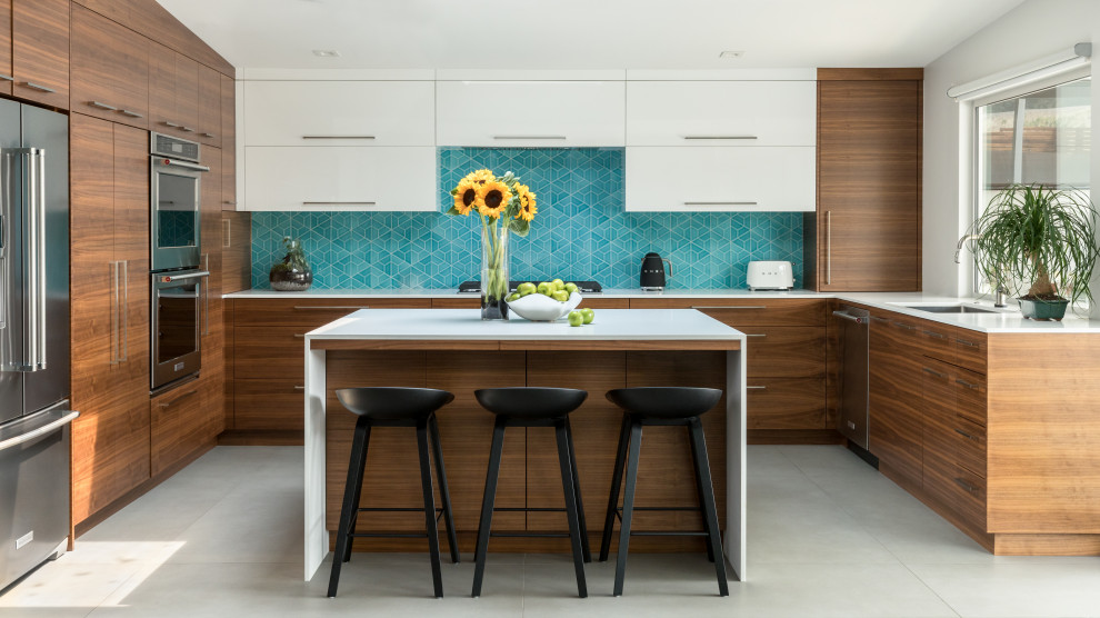 Design ideas for a midcentury u-shaped kitchen in Sacramento with an undermount sink, flat-panel cabinets, white cabinets, blue splashback, stainless steel appliances, concrete floors, with island, grey floor and white benchtop.