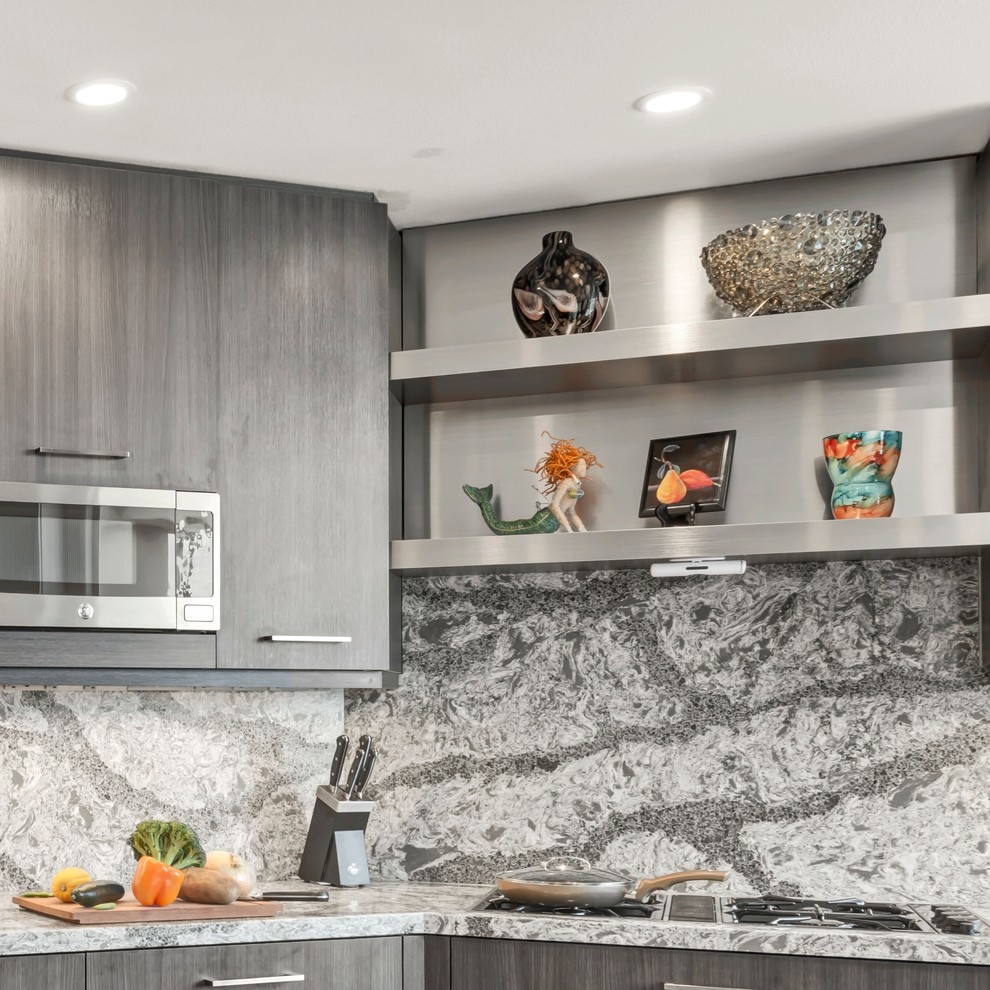 Design ideas for a large modern u-shaped kitchen in Los Angeles with a farmhouse sink, flat-panel cabinets, medium wood cabinets, quartzite benchtops, grey splashback, stainless steel appliances, porcelain floors, grey floor and grey benchtop.