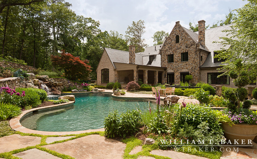Expansive transitional backyard custom-shaped aboveground pool in Atlanta with a water feature and natural stone pavers.