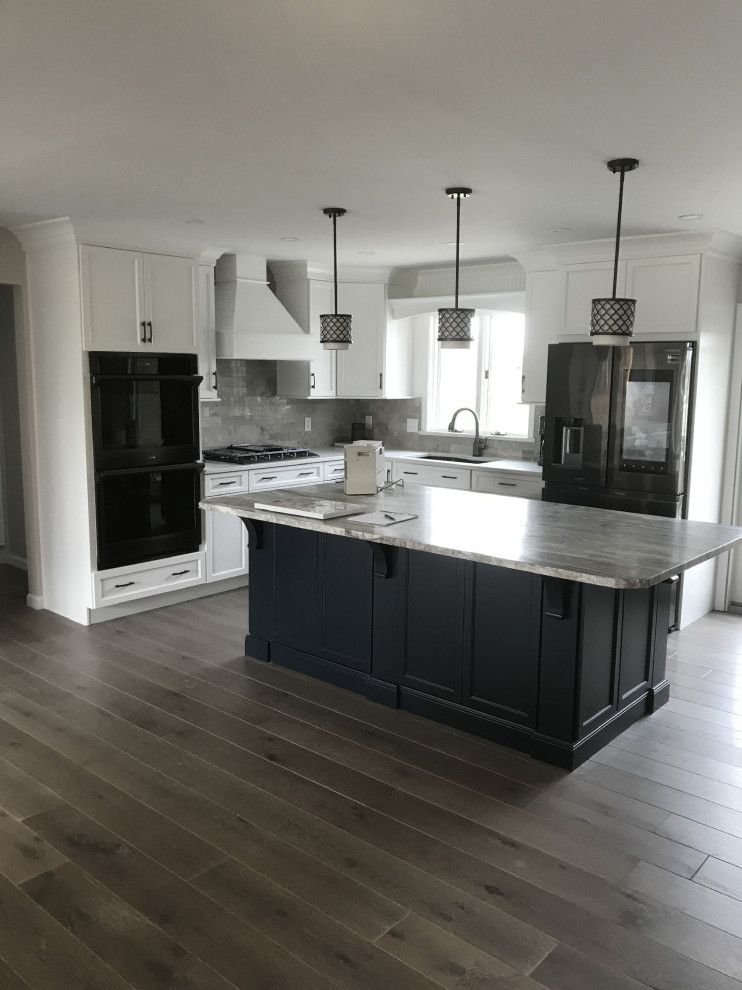 Inspiration for a large transitional l-shaped vinyl floor and gray floor eat-in kitchen remodel with an undermount sink, recessed-panel cabinets, white cabinets, quartz countertops, gray backsplash, ceramic backsplash, stainless steel appliances, an island and white countertops