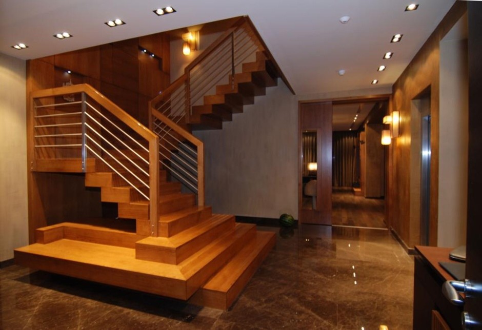 На фото: большая п-образная деревянная лестница в стиле неоклассика (современная классика) с деревянными ступенями и деревянными перилами