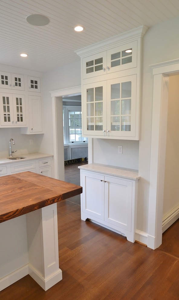 This is an example of an expansive transitional l-shaped eat-in kitchen in Philadelphia with an undermount sink, recessed-panel cabinets, white cabinets, wood benchtops, stainless steel appliances, medium hardwood floors, with island, brown floor and beige benchtop.