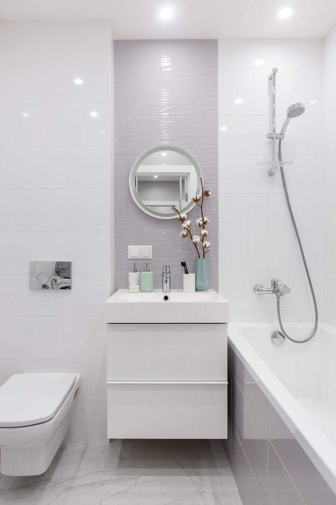 Small master bathroom in Moscow with flat-panel cabinets, white cabinets, an undermount tub, a wall-mount toilet, gray tile, ceramic tile, white walls, porcelain floors, a wall-mount sink, solid surface benchtops, grey floor and white benchtops.