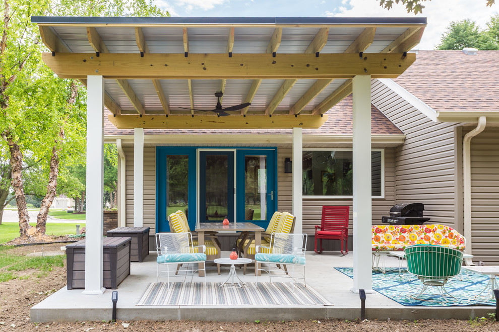 Mid-sized transitional backyard patio in Omaha with concrete slab and a pergola.
