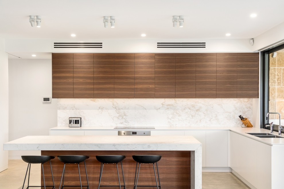 Design ideas for a mid-sized contemporary galley eat-in kitchen in Sydney with a double-bowl sink, flat-panel cabinets, white cabinets, marble benchtops, white splashback, marble splashback, stainless steel appliances, concrete floors, with island and beige floor.