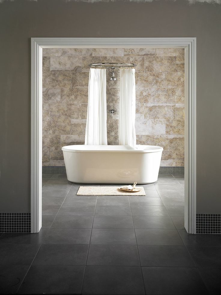 Inspiration for a large traditional bathroom in London with a freestanding tub, a shower/bathtub combo, brown tile, stone slab, brown walls and slate floors.
