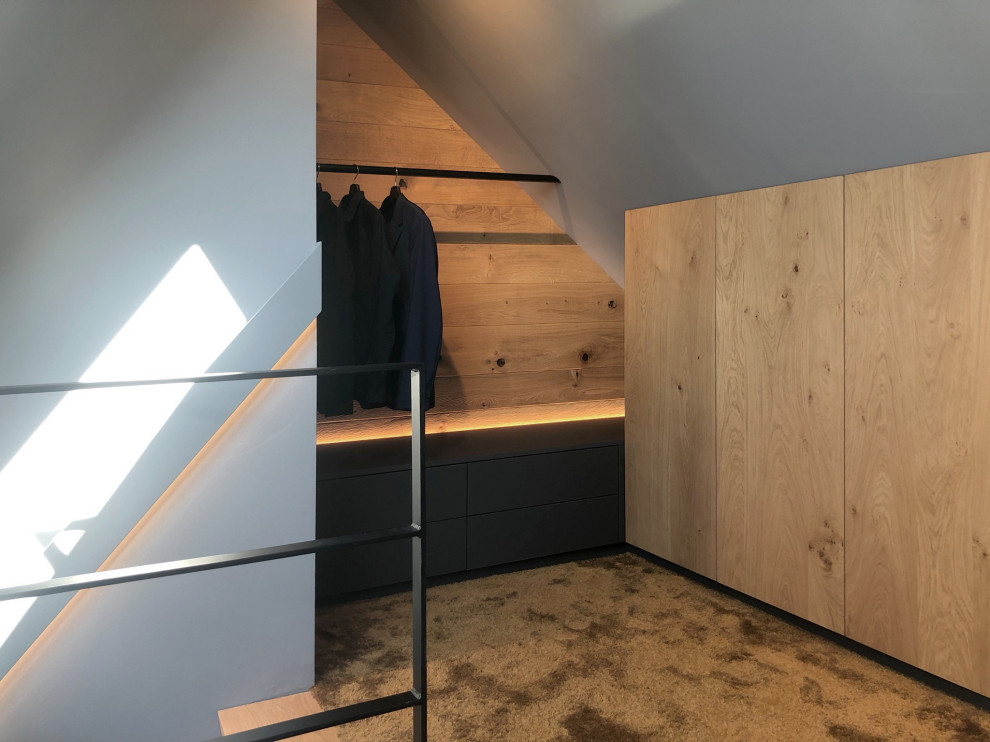 Ankleidezimmer mit Ankleidebereich, flächenbündigen Schrankfronten, hellbraunen Holzschränken und Teppichboden in Cologne