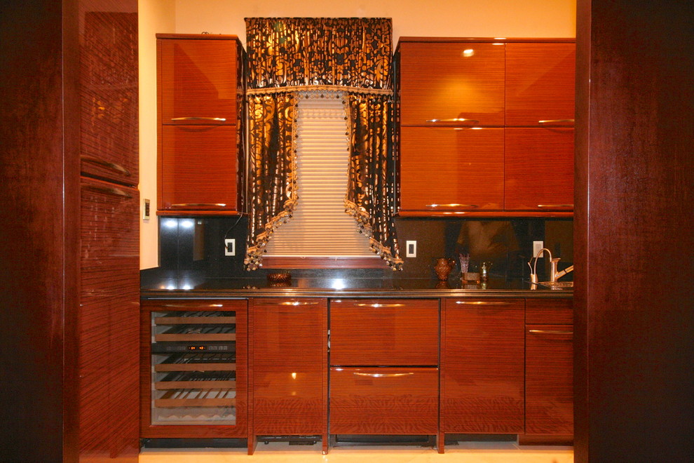 Photo of a mid-sized mediterranean single-wall separate kitchen in Miami with flat-panel cabinets, medium wood cabinets, black splashback, panelled appliances, no island and ceramic floors.