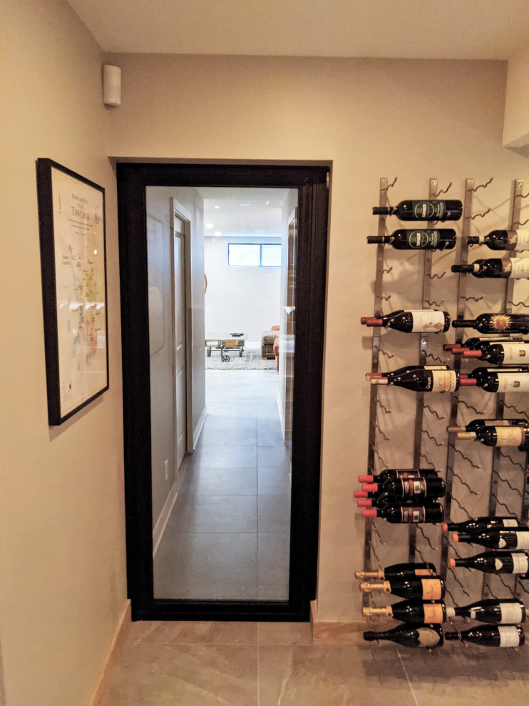 This is an example of a mid-sized contemporary wine cellar in Montreal with porcelain floors, display racks and grey floor.