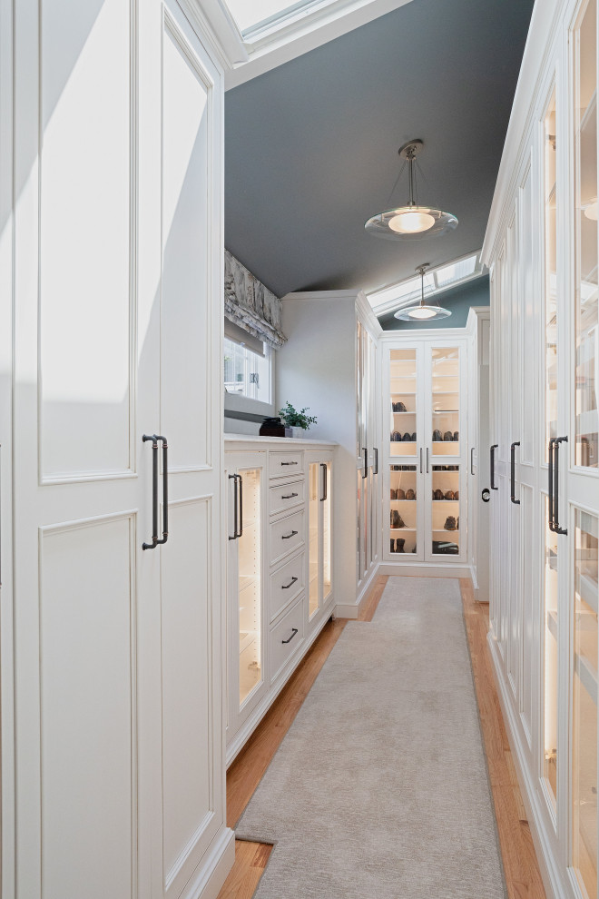 Design ideas for a large beach style gender-neutral storage and wardrobe in Bridgeport with recessed-panel cabinets, white cabinets, carpet, grey floor and vaulted.
