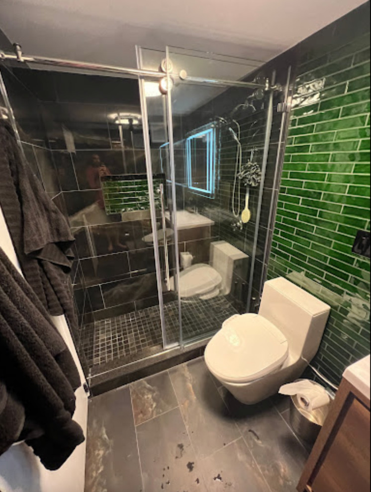 Immagine di una piccola stanza da bagno minimalista con pareti verdi, pavimento con piastrelle in ceramica, lavabo integrato, pavimento nero e mobile bagno freestanding