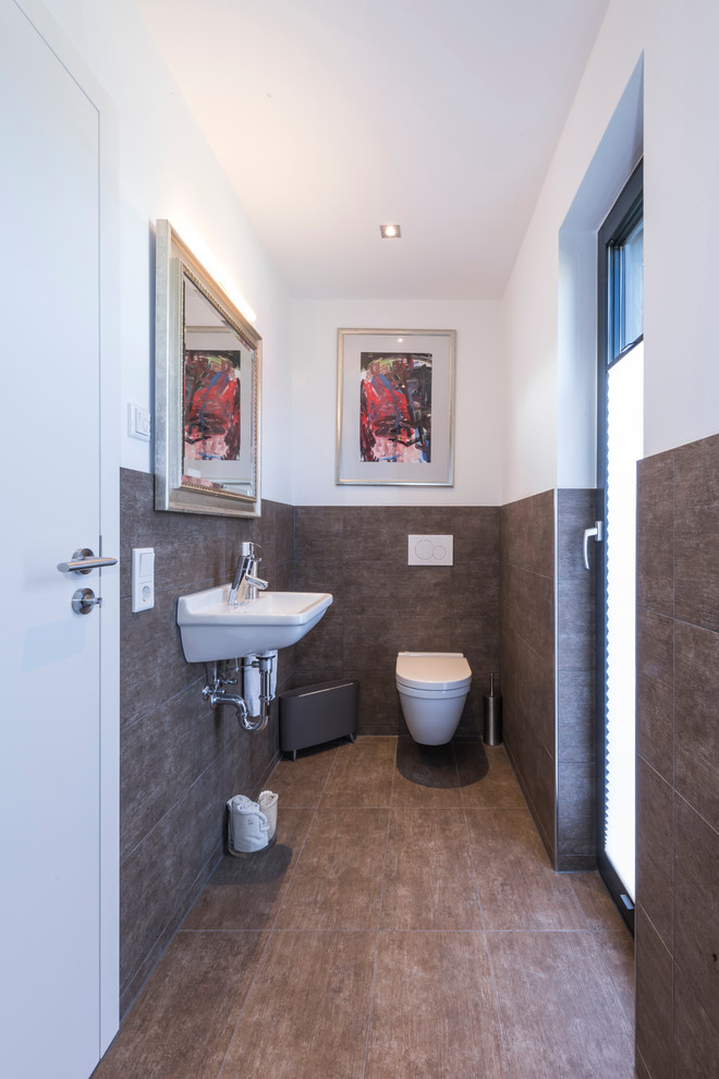 This is an example of a mid-sized contemporary powder room in Other with a wall-mount toilet and a wall-mount sink.