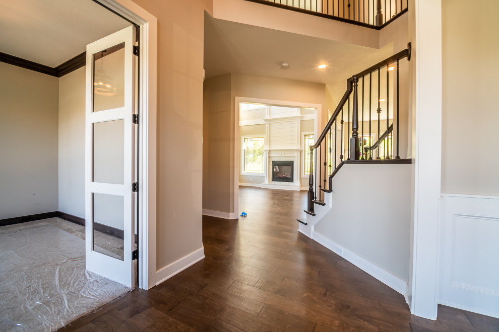 Inspiration for a mid-sized transitional medium tone wood floor and brown floor foyer remodel with beige walls and a black front door
