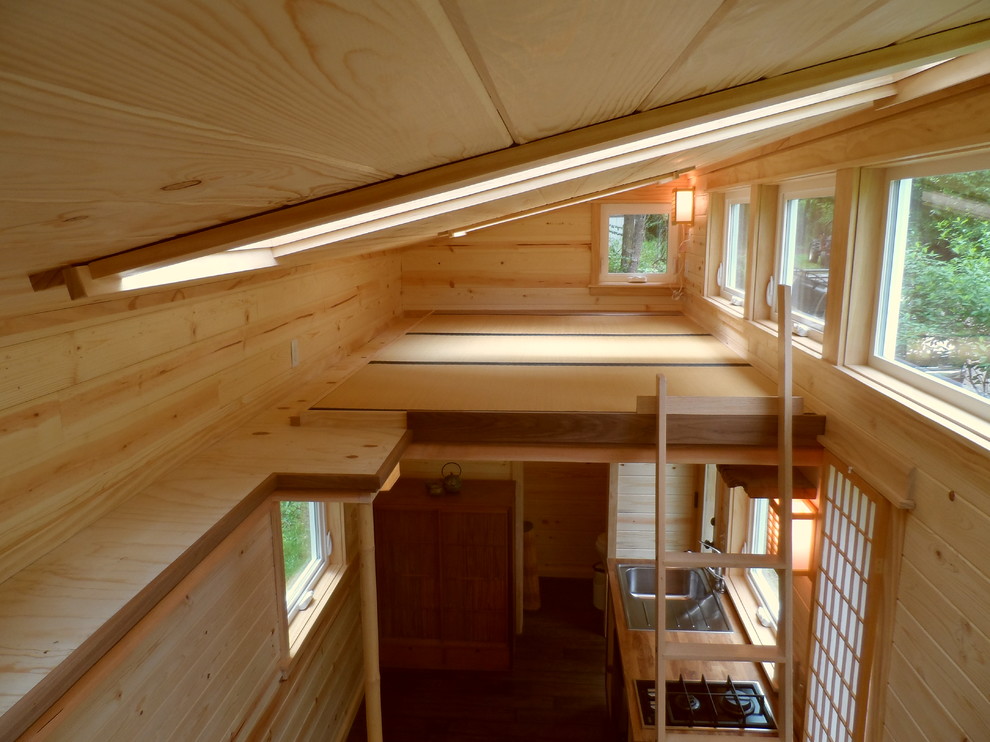 Inspiration for a small loft-style light wood floor bedroom remodel in Portland with brown walls