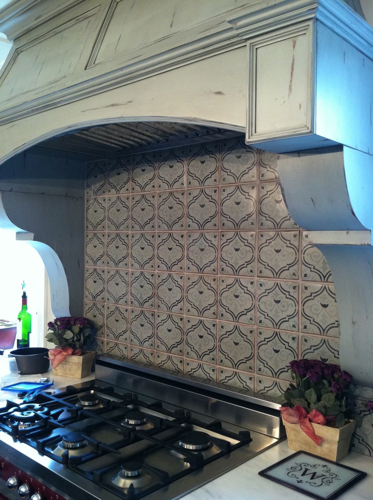 Eat-in kitchen - rustic eat-in kitchen idea in New York with gray backsplash, terra-cotta backsplash, stainless steel appliances, distressed cabinets and marble countertops